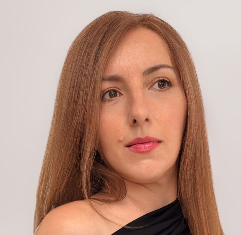 žena u elegantnoj crnoj off-shoulder haljini u minimalističkom okruženju